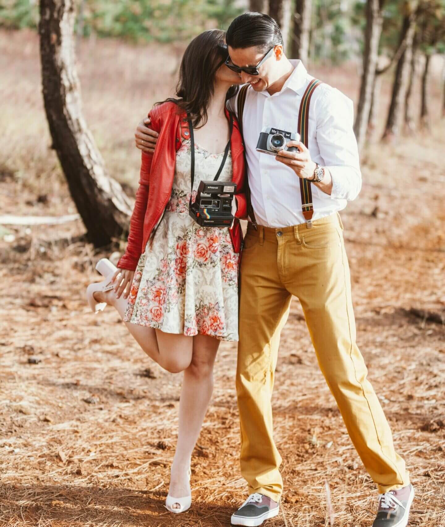 Couple dressed in vintage attire walking closely outdoors.